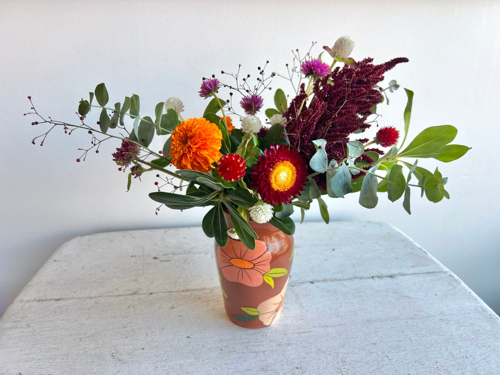 warm seasonal flower arrangement with orange printed vase by stem & vine in Biddeford, Maine