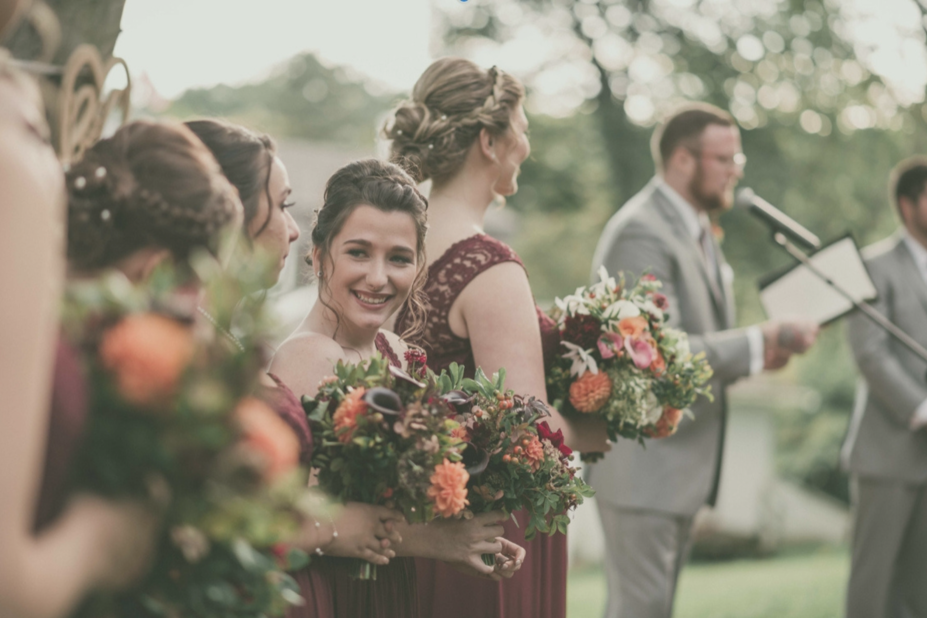bridal party holding bouquets of flowers for a fall season wedding in maine
