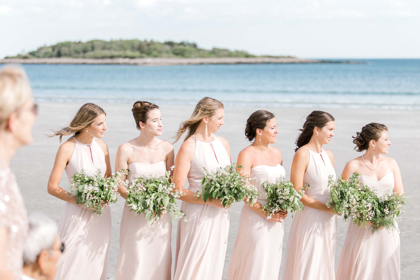 women with bouquets on the beach for a wedding